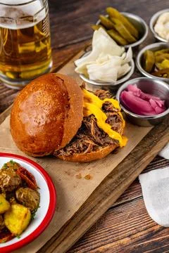 Slow cooked pulled rib beef burger with melted cheese and sides Stock Photos