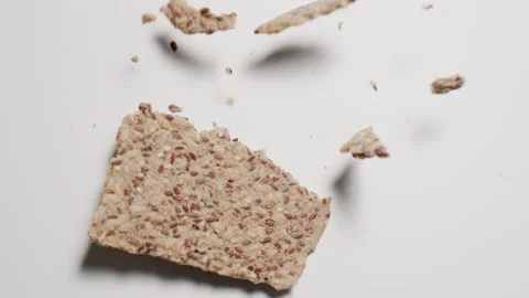 SLOW: Crispbread falls on a white table - Top view Видео 144416360