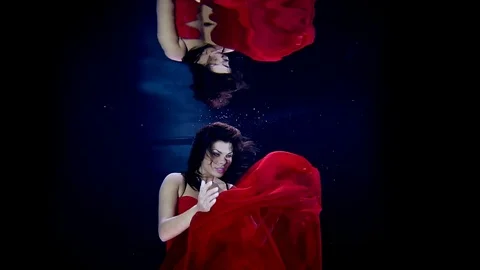Slow dance in the water in the dark with the lights reflected in the surface of 스톡 동영상 73816820