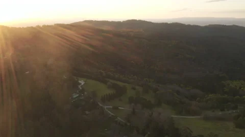 Slow decent over mountain region during dusk with lens flare. Stock Footage 161209408