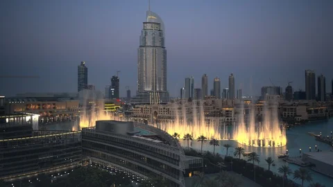 Slow descent down Burj Khalifa, track forwards and backwards from dubai fountain Stock Footage 98960798