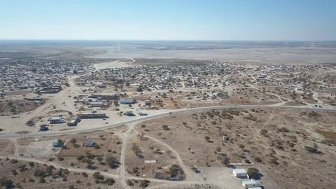 Slow descent to ground level from above dry African town Vídeo Stock 80988597