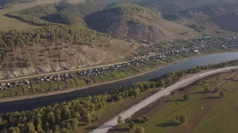 Slow direct aerial flight over mountain village, river, forest, country road Video stock 84037732