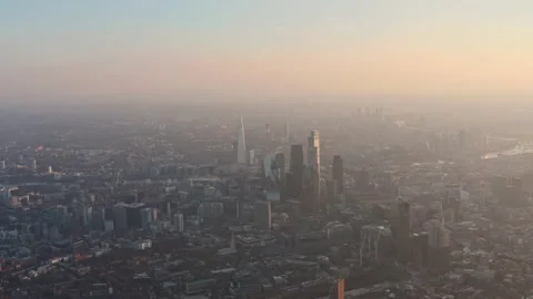 Slow dolly forward drone shot towards city of London skyscrapers at sunset Vídeos de archivo 151806893