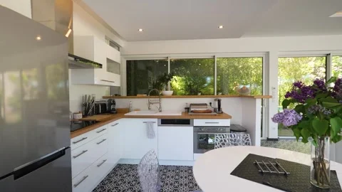 Slow dolly shot showing a kitchen and dining area within a villa in Nimes Stock Footage 248741870
