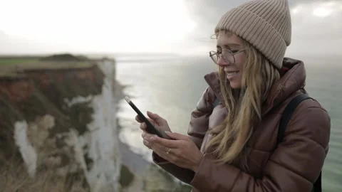 Slow Down To Enjoy Your Trip, Traveler woman use smart phone on shore in Stock Footage 135616540