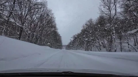 Slow driving in snowfall on remote snowy mountain road POV no traffic Video stock 333091341