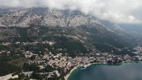 Slow Drone aerial over Brela Beach Croatia calm day, light cloud blue sky Stock Footage 285270702