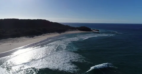 Slow drone aerial view of sun reflecting off beach ocean waves Stock Footage 78328347