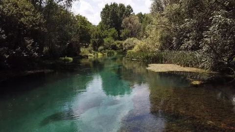 Slow drone clip flying in reverse through the trees just above the crystal Stock Footage 113345148