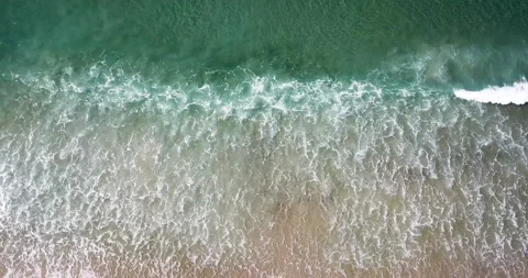 Slow drone decent over abstract aqua water, waves and beach Video stock 237782903