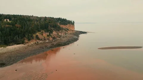 Slow Drone Flight Over Atlantic Ocean During Low Tide Focusing On Cliffside Stock Footage 254996041