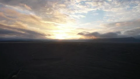 Slow drone flight over black sand plain toward sunset clouds, Skeidararsandur Stock Footage 346552351