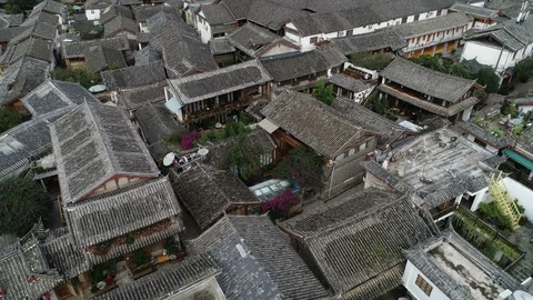 Slow drone flight over courtyard homes and hotels in old village Lijiang, China Stock Footage