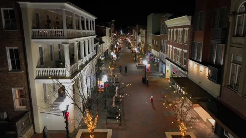 Slow drone flight over festive decorated street of American city. Dark night Stock Footage 296325122