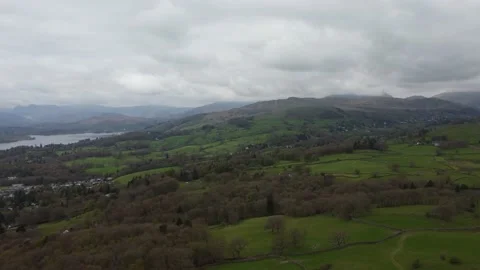 Slow drone flight over fields &amp; hills with lake Stock Footage 239992823