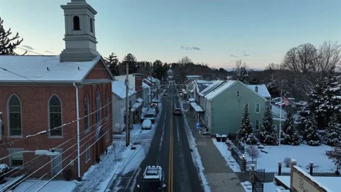 Slow drone flight over small American town in winter. Snow lines streets and Vídeo Stock 328599272