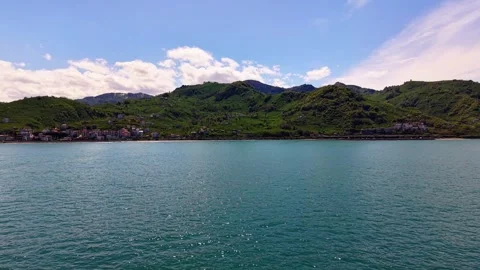 Slow Drone Flight From Sea Toward Green Coastline in 4K Video stock 337790021