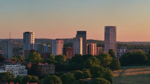 Slow drone flyby over sunset-lit skyscrapers and green park in cinematic style Stock Footage 309769592