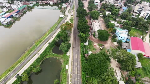 Slow Drone Flyforward of Railway Track, Large Pond and Bus Station in Ishwardi Stock Footage 335879258