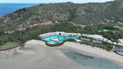 Slow drone orbit in daytime around the Hayman Island resort pool precinct Video stock 331025209