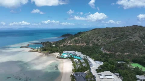 Slow drone pullback in daytime with a gentle rise, widening from Hayman Island Stock Footage 331025380