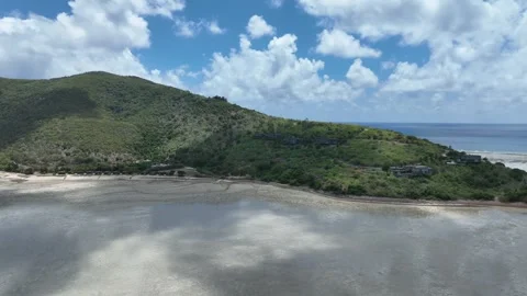 Slow drone pullback in daytime, widening from the shallow bay flats to reveal Stock-Footage 331025563