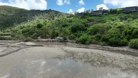 Slow drone pullback with a gentle rise in daytime, widening from the rocky Stock Footage 331025536
