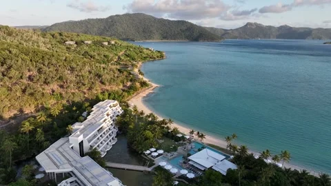 Slow drone pullback, widening from the Hayman Island beachfront resort and Vídeos de archivo 331025974