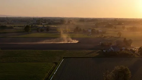Slow drone push in over spring tractor work at sunset in Po Valley Italy Видео 335968447