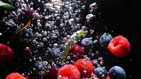 Slow drop of blueberry strawberry raspberry into water on black background Stock Footage 156814326