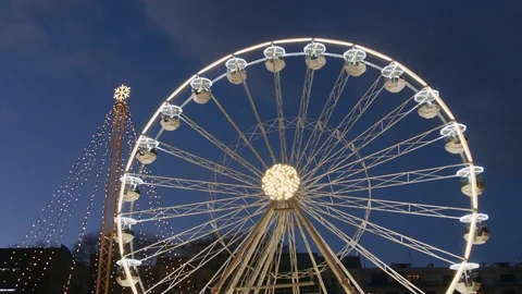 Slow ferris wheel in lights and Christmas tree in evening Stock Footage 99832142