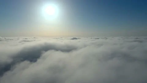 Slow flight above cloudtops towards sun 스톡 동영상 135250441