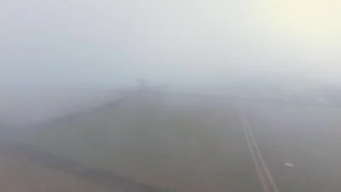 Slow flight aerial view over misty agricultural fields in Looe, Cornwall Video stock 343661525