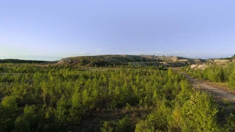 Slow flight forward over forested recultivated barrens to the distant hills Stock Footage 220625963