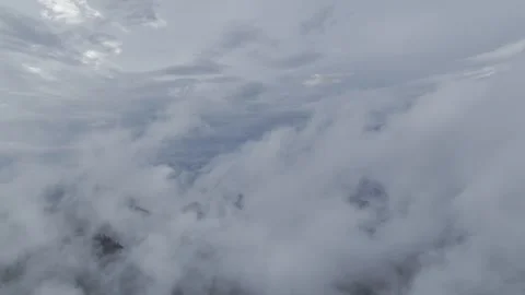A slow flight over the mountains through thick gray clouds. Stock Footage 281007134