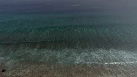 Slow flight over the ocean surface. Smooth flight over crystal clear waters. Stock Footage 148472468