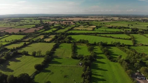Slow flight over a patchwork of fields in England. Sunshine. Video stock 247495936