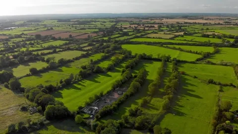 Slow flight over a patchwork of fields in England. Sunshine. Video stock 247496040