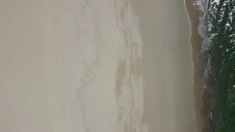 Slow flight over the sandy beach, view from the height of the waves on the shore Stock Footage 169916579