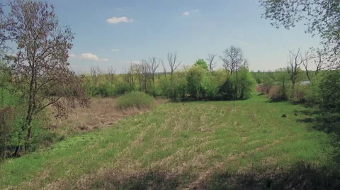 A slow flight over a small field to reveal a river Video stock 63929647