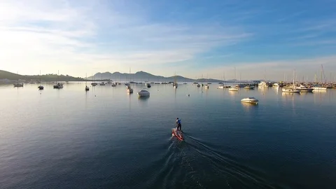 Slow fly over isolated paddle boarder during sunrise hours at Pollenca Bay, M Stock Footage 101018180