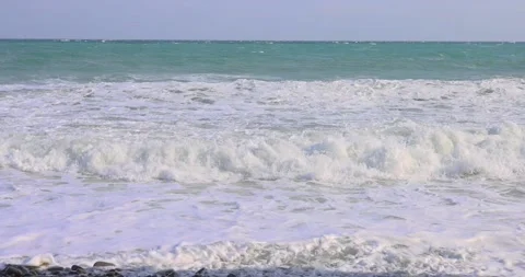 Slow, foamy waves on a rough sea day Stock Footage 213239446