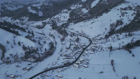 Slow forward aerial over snowy mountain valley village Stock Footage 341764222