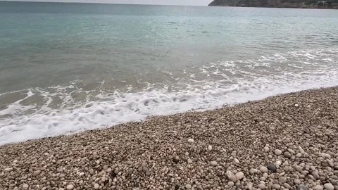 Slow forward camera movement across a pebble beach toward gentle Mediterran.. Stock Footage 343226184