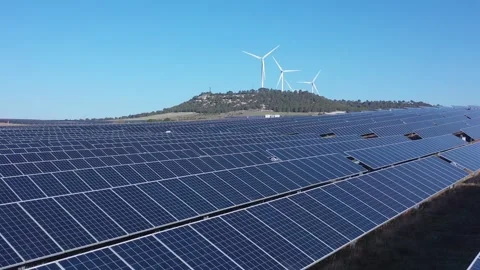 Slow Forward Drone Flight Over Solar Panels with Wind Turbines in Distance Stock Footage 329710117