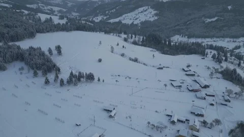 Slow forward drone flight over snowy mountain farmland Stock Footage 341767063