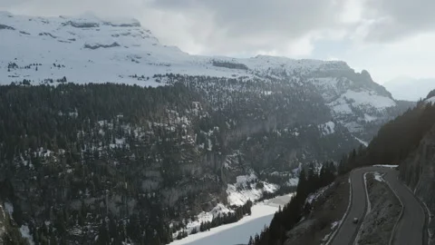 Slow Forward Moving Drone Shot Over Hairpin Road in Snowy Alpine Valley 動画素材 326529225