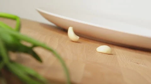 SLOW: A garlic falls on a table Stock Footage 62588136