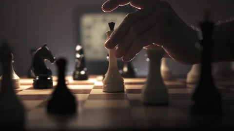 Slow grace hand movement places a white queen in the center of a chessboard Stock Footage 312811005